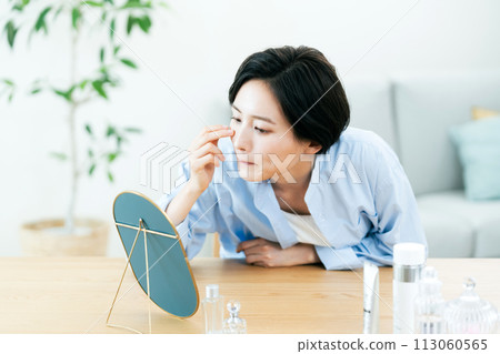 A woman taking care of her skin in the living room 113060565