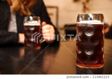 Dark beer. Two friends enjoying dark beer together, perfect for use in advertisements for breweries, pubs, or social gathering venues. Banner for design with copy space Dark beer. Two friends enjoying dark beer together, perfect for use in advertisements for breweries, pubs, or social gathering venues. Banner for design with copy space 113061223