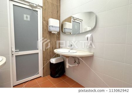 single sink in small public toilet with wall soap dispenser and paper towlels single sink in small public toilet with wall soap dispenser and paper towlels 113062942