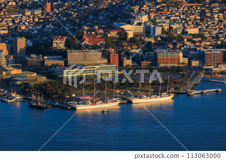 The port and sailing ships of the hill town of Nagasaki illuminated by the setting sun The port and sailing ships of the hill town of Nagasaki illuminated by the setting sun 113063000