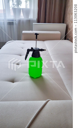 A specialist sprays cleaning agent on an office chair to remove stains. General cleaning. 113063208