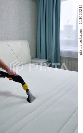 The concept of cleaning and housekeeping. Dry cleaning of the mattress by a professional method. 113063212