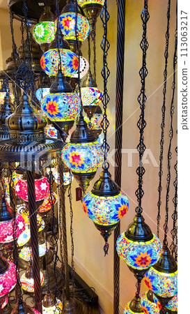 Mosaic of colored glass. Illuminated in the evening, it creates a cozy atmosphere. Vintage multicolored lamps in traditional Oriental style, Arab-style lanterns 113063217