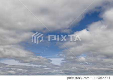 Layers of fluffy clouds contrast against clear blue sky, offering a dynamic, versatile backdrop Layers of fluffy clouds contrast against clear blue sky, offering a dynamic, versatile backdrop 113063341