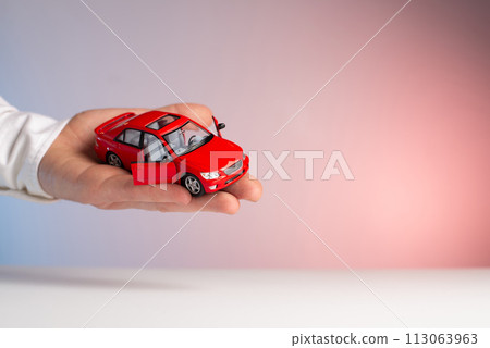 Red toy car in man hand. Sale car 113063963