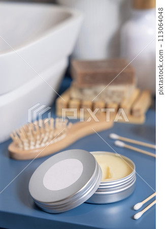 Opened body butter jar near personal care products on blue close up, cosmetic mockup Opened body butter jar near personal care products on blue close up, cosmetic mockup 113064048