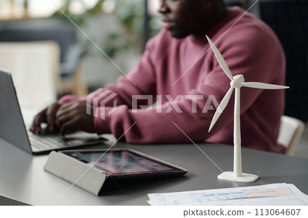 Windmill model standing next to tablet Windmill model standing next to tablet 113064607