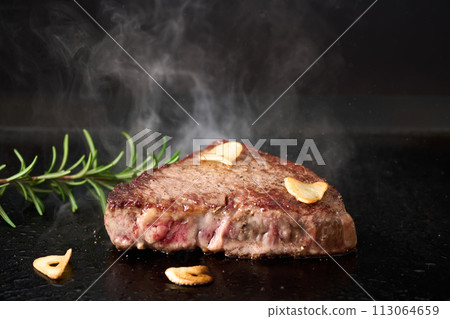 Grilling beef thigh steak on a griddle 113064659