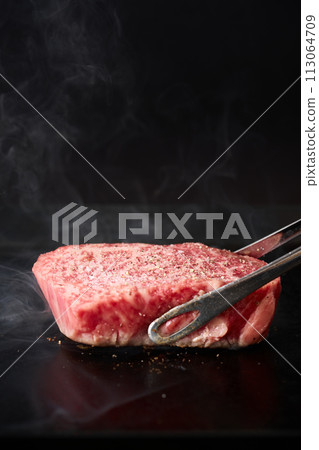 Grilling beef thigh steak on a griddle Grilling beef thigh steak on a griddle 113064709