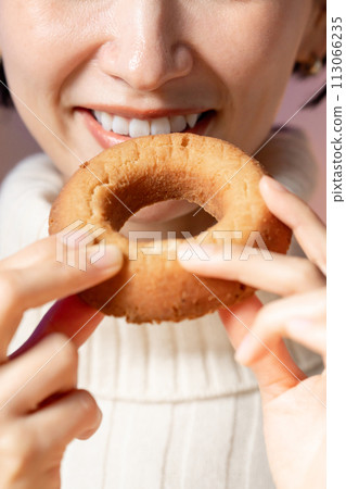 A woman eating a donut 113066235