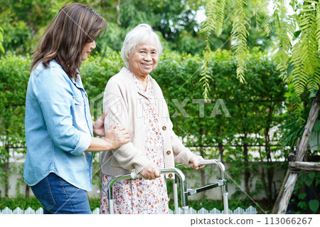 Caregiver help Asian elderly woman disability patient walk with walker in park, medical concept. Caregiver help Asian elderly woman disability patient walk with walker in park, medical concept. 113066267