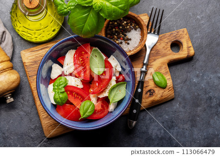 Caprese salad with ripe tomatoes, mozzarella cheese and garden basil Caprese salad with ripe tomatoes, mozzarella cheese and garden basil 113066479