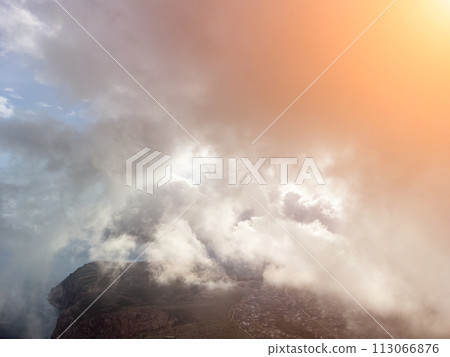 Aerial view. The drone flies over foggy and fluffy clouds. Blue sky sun and sea fog. Abstract aerial nature summer ocean sunset sea and sky background. Horizon. Vacation, travel and holiday concept 113066876
