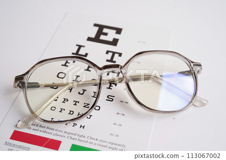Glasses on eye exam chart to test eyesight accuracy of reading. Glasses on eye exam chart to test eyesight accuracy of reading. 113067002