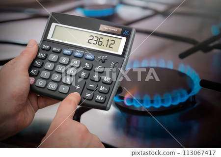 Man counts gas bills on a calculator Man counts gas bills on a calculator 113067417
