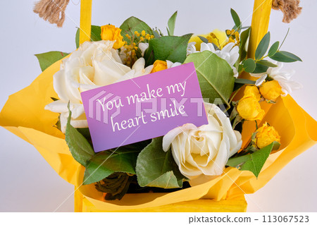 You Make My Heart Smile text on a business card in a basket with blooming flowers You Make My Heart Smile text on a business card in a basket with blooming flowers 113067523