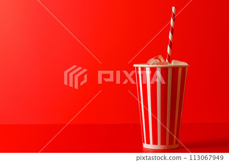 Paper cup with cola and ice over red background 113067949