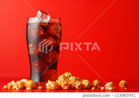 Cola with ice over red background 113067951