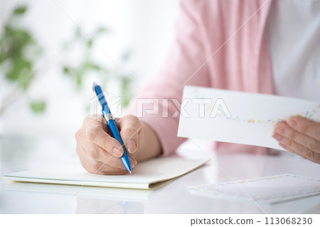 Hand of a middle-aged woman writing a letter Hand of a middle-aged woman writing a letter 113068230