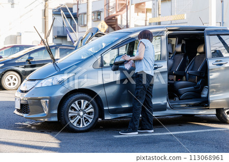 A woman polishing her car at a car wash A woman polishing her car at a car wash 113068961