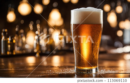 Frothy beer being poured into a chilled glass 113069110