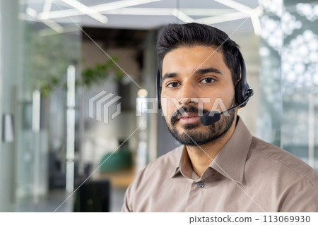 Focused customer service representative with headset working in a bright, contemporary office environment. Focused customer service representative with headset working in a bright, contemporary office environment. 113069930