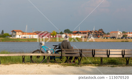 senior man sitting on a bench looking at the sea senior man sitting on a bench looking at the sea 113070520