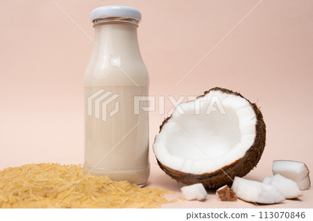 Rice coconut vegan milk in glass bottles on beige background 113070846