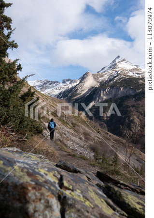 Hiker walking on the path in Pyrenees mountains near Gavarnie Hiker walking on the path in Pyrenees mountains near Gavarnie 113070974