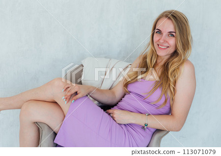 Beautiful blonde woman in summer dress on chair Beautiful blonde woman in summer dress on chair 113071079