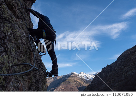 Man in body harnesses feature life-safety, viaferrata in mountains of pyrenees Man in body harnesses feature life-safety, viaferrata in mountains of pyrenees 113071090