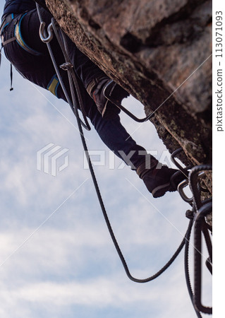 Man in body harnesses feature life-safety, viaferrata in mountains of pyrenees Man in body harnesses feature life-safety, viaferrata in mountains of pyrenees 113071093