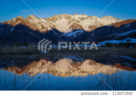 Sunset over the Pyrenees mountains with the reflection of the peaks in the water of the lake Sunset over the Pyrenees mountains with the reflection of the peaks in the water of the lake 113071095