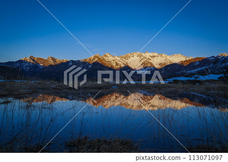 Sunset over the Pyrenees mountains with the reflection of the peaks in the water of the lake Sunset over the Pyrenees mountains with the reflection of the peaks in the water of the lake 113071097