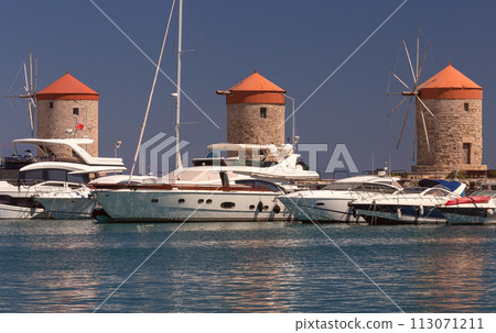 Old windmills on the waterfront of Rhodes on a sunny day. 113071211