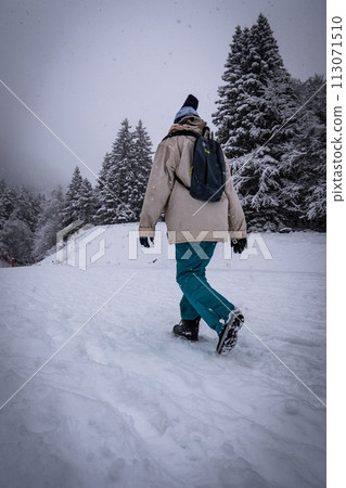 Winter sport activity, Woman hiker hiking with backpack on snow trail forest in Pyrenees, France 113071510