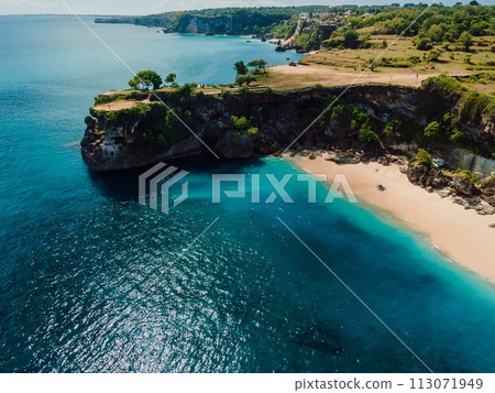 Aerial view of sandy beach with scenic rock and blue sea in Bali 113071949