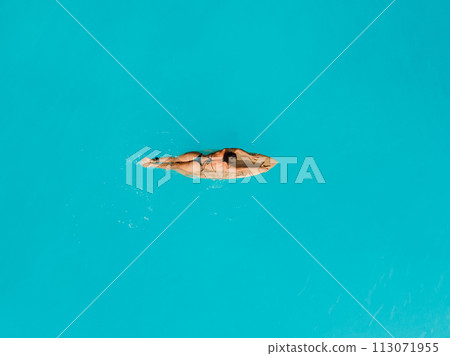 Surf girl relaxing on surfboard in ocean. Aerial view of woman during surfing Surf girl relaxing on surfboard in ocean. Aerial view of woman during surfing 113071955
