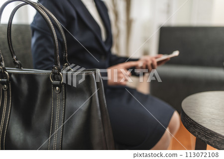 Woman operating a smartphone 113072108