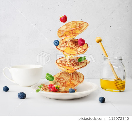 Flying pancakes and berries topped with honey, pancake levitation, 113072540