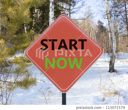 Start now symbol. Concept words Start now on beautiful red road sign. Beautiful forest snow blue sky background. Business marketing, motivational start now concept. Copy space. 113072579