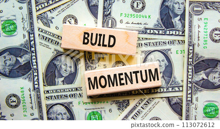 Build momentum symbol. Concept words Build momentum on wooden blocks. Beautiful background from dollar bills. Business and build momentum concept. Copy space. Build momentum symbol. Concept words Build momentum on wooden blocks. Beautiful background from dollar bills. Business and build momentum concept. Copy space. 113072612