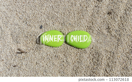 Inner child symbol. Concept words Inner child on beautiful green stone. Beautiful sea sand beach background. Psychological, motivational inner child concept. Copy space. Inner child symbol. Concept words Inner child on beautiful green stone. Beautiful sea sand beach background. Psychological, motivational inner child concept. Copy space. 113072618