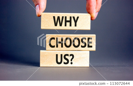 Why choose us symbol. Concept word Why choose us on beautiful wooden block. Businessman hand. Beautiful grey table grey background. Business motivational why choose us concept. Copy space. 113072644