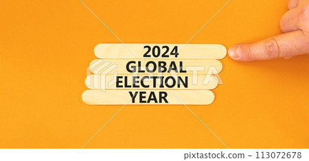 2024 global election year symbol. Concept words 2024 global election year on wooden stick. Beautiful orange table orange background. Voter hand. Business 2024 global election year concept. Copy space. 2024 global election year symbol. Concept words 2024 global election year on wooden stick. Beautiful orange table orange background. Voter hand. Business 2024 global election year concept. Copy space. 113072678