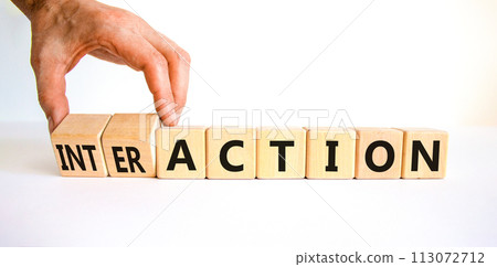 Action or interaction symbol. Businessman turns wooden cubes and changes the word action to interaction. Beautiful white table white background, copy space. Business and action or interaction concept. 113072712