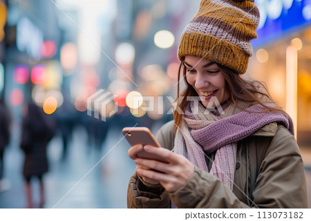 young smiling woman looking at his smartphone in his hand in the city street young smiling woman looking at his smartphone in his hand in the city street 113073182