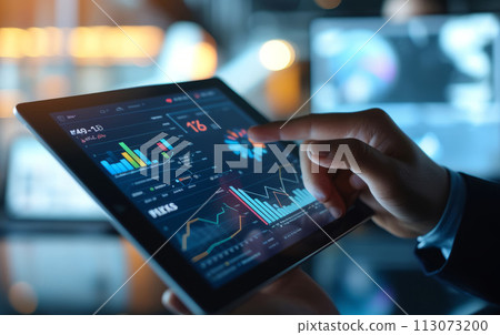 businessman's hand holds a tablet with a graph image on the display 113073200