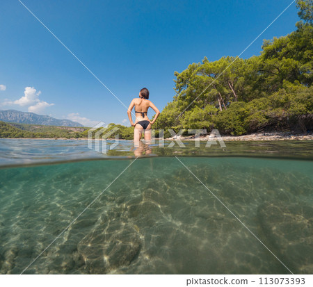 Woman on tropical vacation paradise on sea. Summer sea joy in Turkish seacoast, beaches along Lycian Way, Turkish Riviera. Asian female underwater and turquoise ocean around. Woman on tropical vacation paradise on sea. Summer sea joy in Turkish seacoast, beaches along Lycian Way, Turkish Riviera. Asian female underwater and turquoise ocean around. 113073393