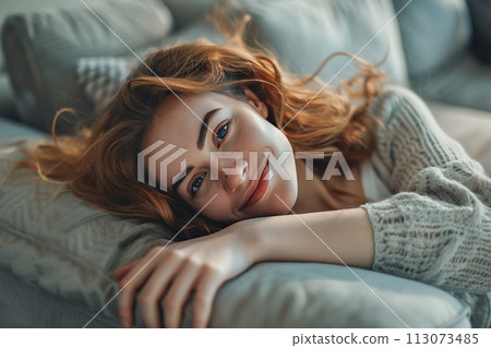Smiling girl enjoying day off lying on the couch, Healthy life style, good vibes, new home concept Smiling girl enjoying day off lying on the couch, Healthy life style, good vibes, new home concept 113073485